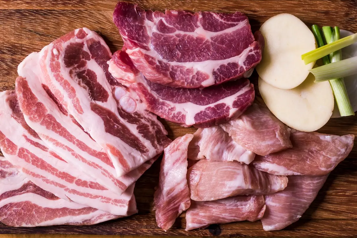 Raw marbled pork cuts on a wooden board